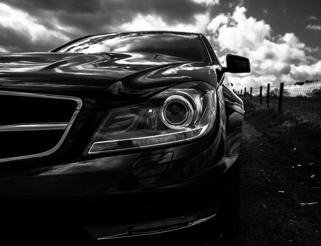 černobílá fotografie automobilu zepředu, záběr na světlo